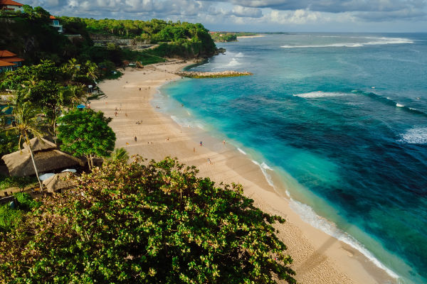 Tropical beach with turquoise ocean and waves in Bali island. Aerial view