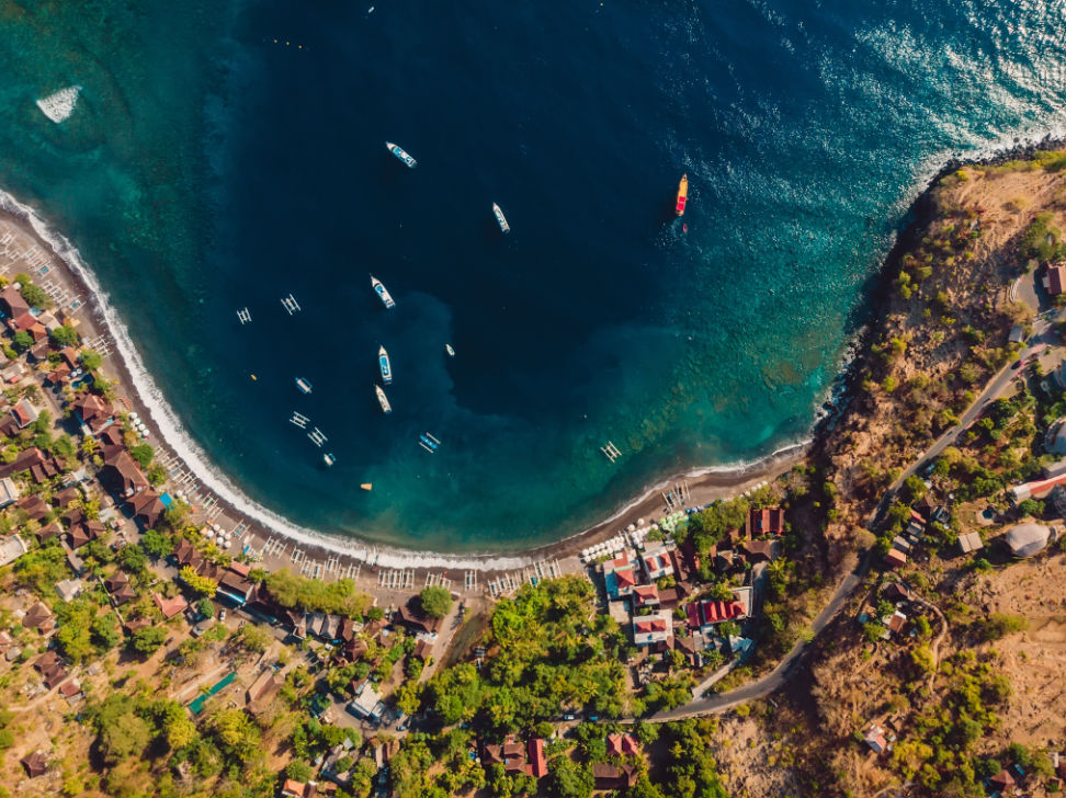 Arial view of Jemeluk Bay in Amed with ocean and mountain views.