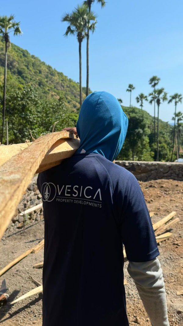 Balinese building contractor carrying wood on Vesica Villas Celuke project in Amed