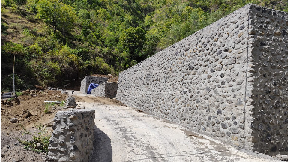 River stone boundary walls supporting villa foundations