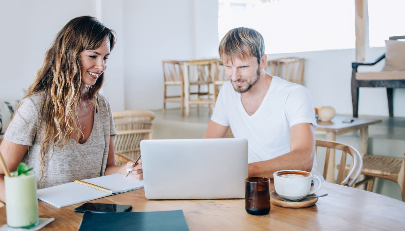 Property investors looking at rental profits on a computer.