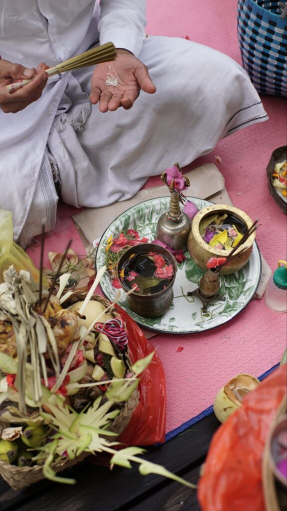 Balinese priest presents offering during a house welcoming ceremony in Amed.