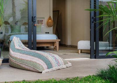 Patterned terrace bean bag looking through open sliding doors into the bedroom at Angin Laut at Vesica Villas Resort in Amed