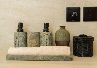 Close-up of rolled towel and stone hand-wash dispensers on a vanity tray at Angin Laut at Vesica Villas Resort in Amed