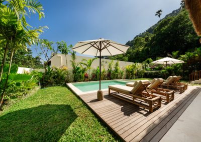 Turquoise private pool and cushioned sun loungers under white umbrellas at Villa Svara at Vesica Villas Resort in Amed.