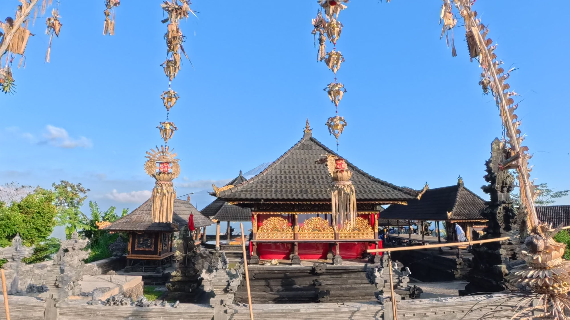 Pura Lempuyan Temple with hanging Penjor and clear blue skies in the background.
