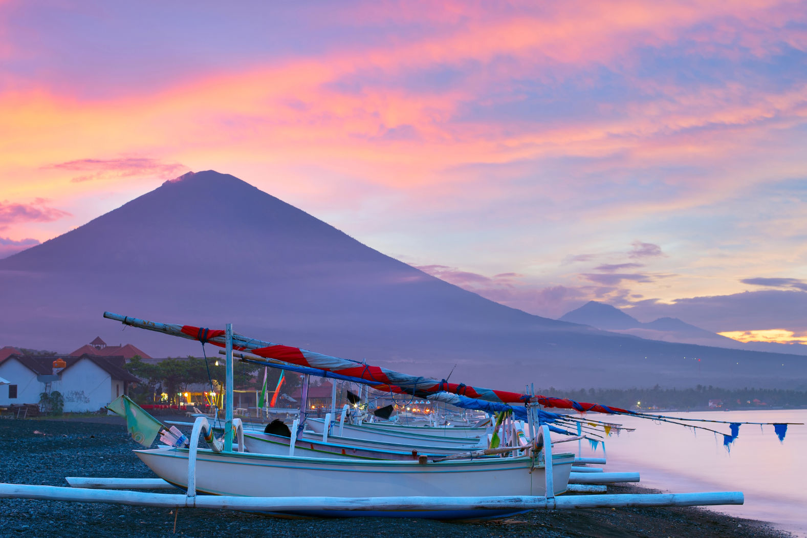 Sunset Boat Trip Amed Beach with jukung boats with Mount Agung at sunset in the background.